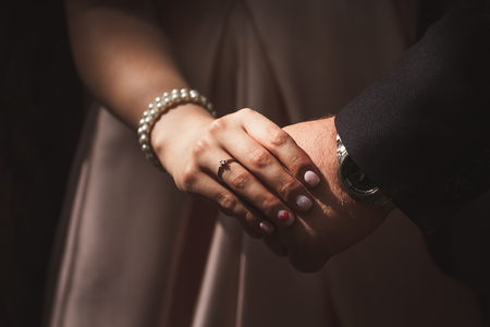 hands bride and groom on blurred background.の写真素材
