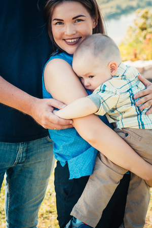 Happy family with baby son on nature background.の写真素材