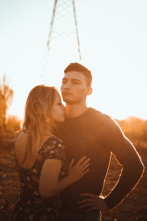 guy and girl in the field on the sunset background.の写真素材