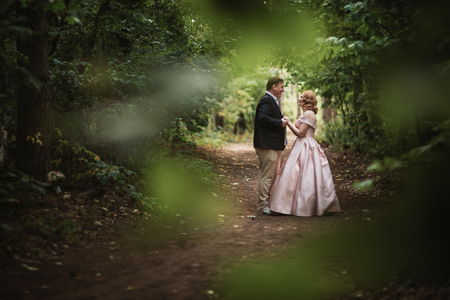 bride and groom dancing in the forest background and sunlight.の写真素材