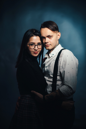 Couple in fashionable clothes on a dark smoky background.の写真素材