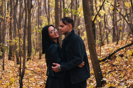 The girl and the guy are walking in the autumn forest.の写真素材