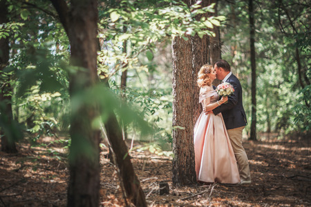 bride and groom on the background of trees and woods in full growth.の写真素材