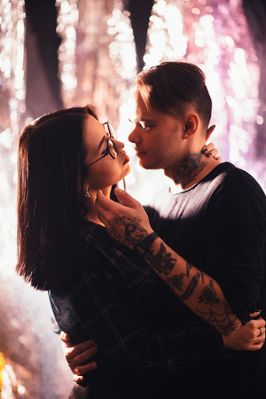Couple in fashionable clothes on a shiny background.の写真素材