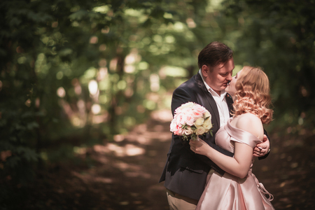 bride and groom dancing in the forest background and sunlight.の写真素材