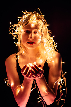 portrait of a girl with a garland on black background.の写真素材