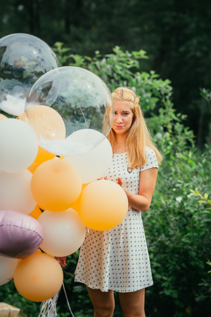 young girl with balloons on nature background.の写真素材