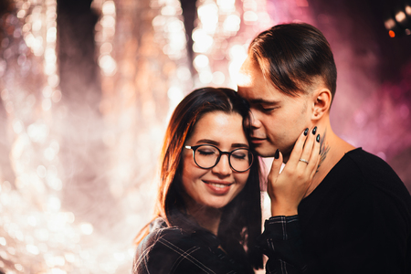 Couple in fashionable clothes on a shiny background.の写真素材