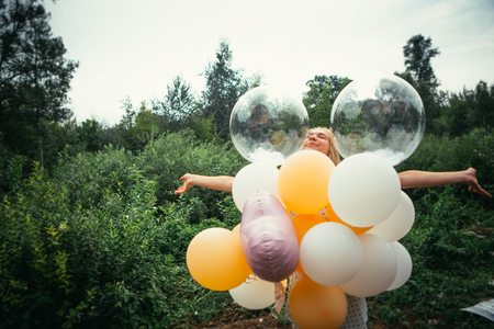 portrait of young girl with balloons on nature background.の写真素材