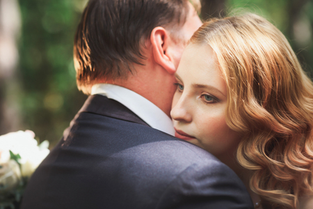 bride and groom on the background of trees and forest sun.の写真素材