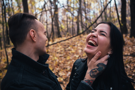 portrait of a young woman and a man walking in the autumn forest.