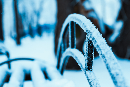 metal fence in hoarfrost on a blurred background.の写真素材