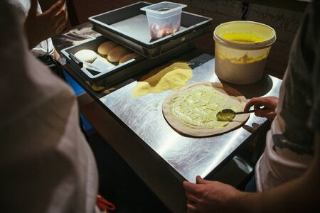 The chef is making pizza. spreads white sauce on the dough.の写真素材