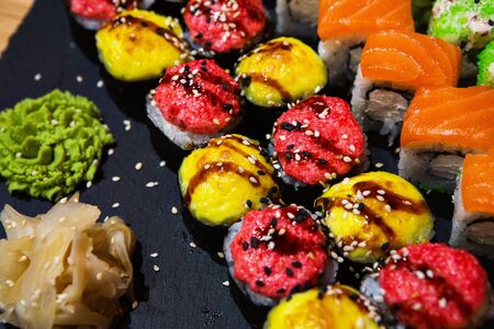 Set of rolls on a black plate with wasabi and ginger.の写真素材