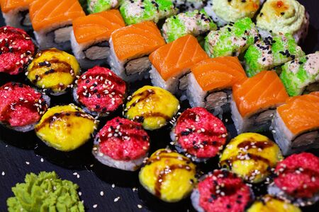 Set of rolls on a black plate with wasabi and ginger.の写真素材