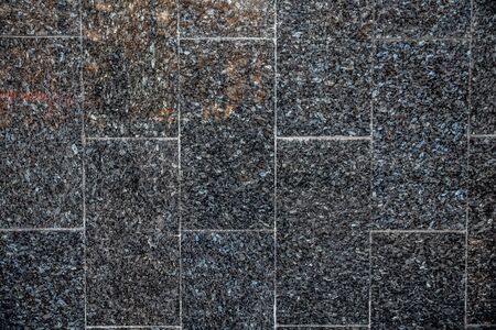 dark granite tiles in small gravelの写真素材