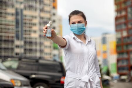 girl in a medical mask shows an antiseptic. focus on antiseptics.の写真素材