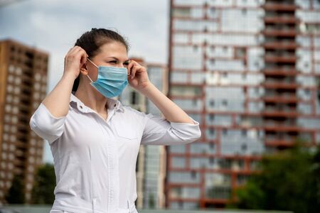girl in a medical mask on the street. girl in a medical mask in the city. girl 20-29 years oldの写真素材