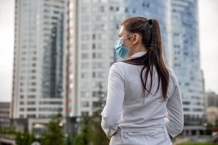 girl in a medical mask on the street. girl in a medical mask in the city. girl 20-29 years oldの写真素材