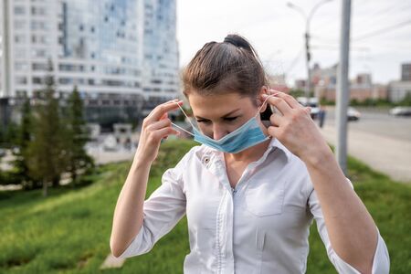 girl in a medical mask on the street. girl in a medical mask in the city. girl 20-29 years oldの写真素材