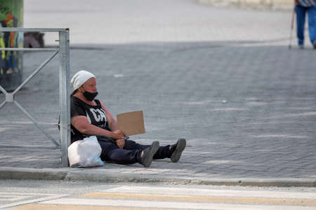 Russia/novosibirsk 11.05.2020 homeless woman asks for alms on the street. homeless woman sitting on...