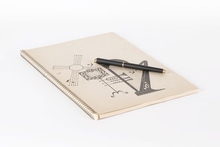 Picture of pen on a musical notebook on a white background