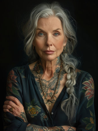 Aging with ink: elderly woman proudly poses with tattoo, showing timeless style and individuality, challenging stereotypes and embracing personal expression through body art.の素材
