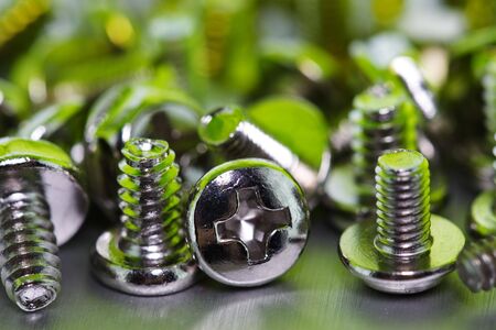 PC screws on the metal plate over green lightの写真素材