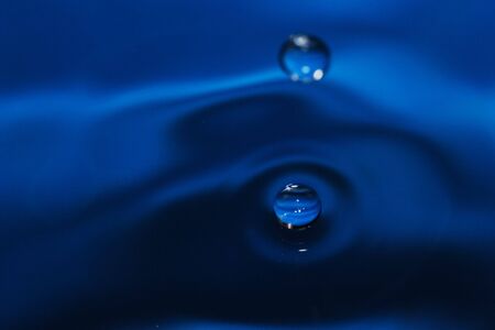 Water drop on the blue waterの写真素材