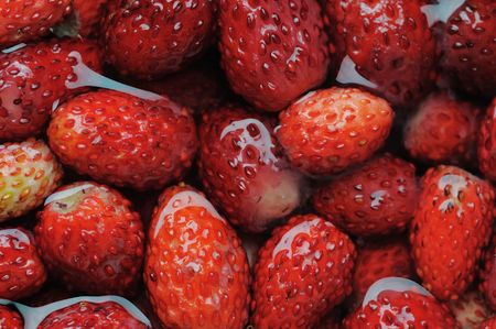 Wild strawberries floating in the water. Narrow depth of field.の写真素材