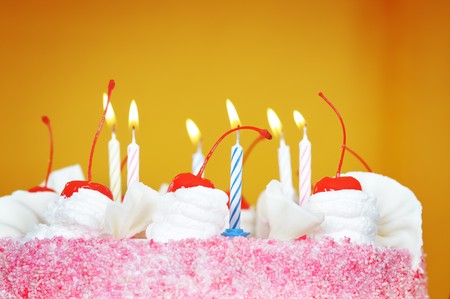 Candles on the birthday cake. Narrow depth of field. Close-up. Orange tint.の写真素材