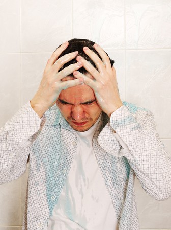Man wearing to the white shirt are washing himself with household chemical goods.の写真素材