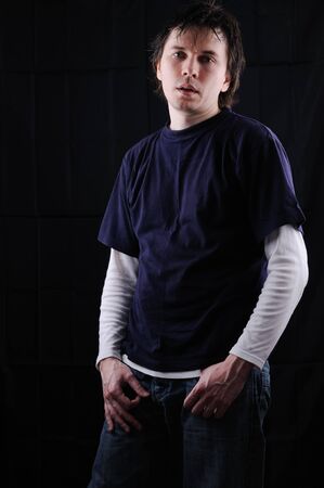 Tired man with wet hair posing on the black background. Looking to the camera.の写真素材