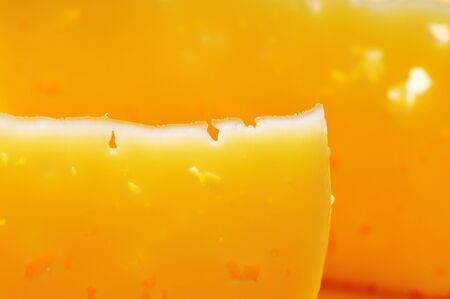 Two thin pieces of cheese on the yellow plate.の写真素材