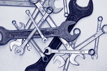 Old and scratched rusty tools on the metal plate. Blue tint.の写真素材