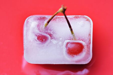 Red cherry frozen in the ice cube.