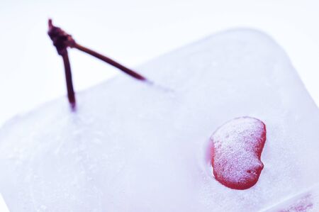 Red cherry frozen in the ice cube.の写真素材