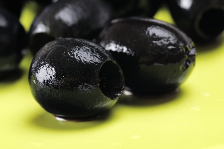Black olives without the stone on the green plate. Narrow depth of field.の写真素材