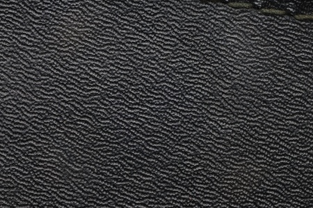 Leather with embossed pattern. Texture. Synthetic material. Black color.
