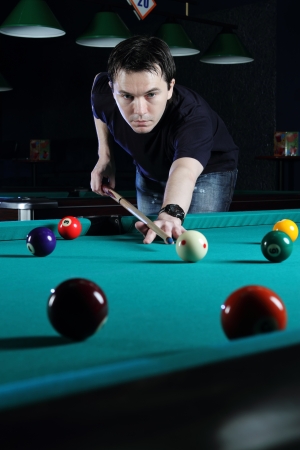 Man playing snooker in the dark club の写真素材