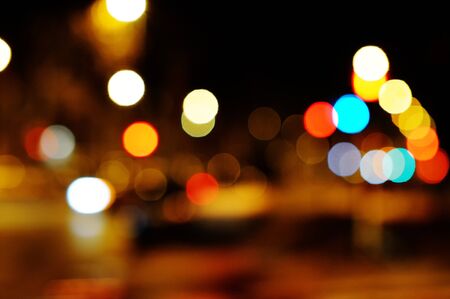 Bright circles from streetlamps on defocused photo of night street 