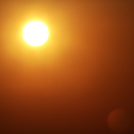 Golden sun in golden sky の写真素材