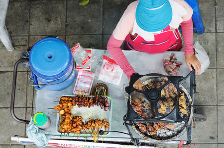 BANGKOK - AUGUST 31: Woman cooks delicious food on the street of Bangkok. Bangkok, Thailand - August 31, 2011.のeditorial素材