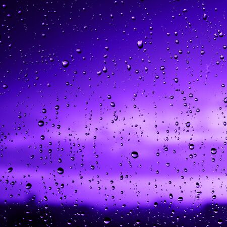 Beautiful sunset after rainy day. View trough the window glass. Defocused.の写真素材