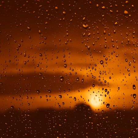 Beautiful sunset after rainy day. View trough the window glass. Defocused.の写真素材