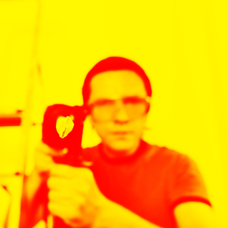 Man with hammer drill in hands. Only drill bit in focus.の写真素材