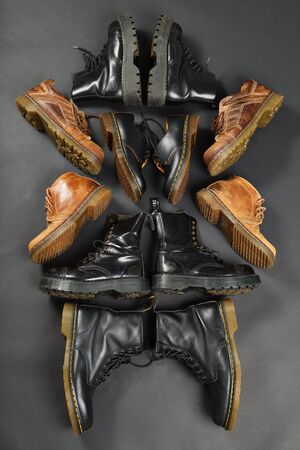 LONDON, ENGLAND - FEBRUARY 4, 2016: Old-fashioned and worn boots on gray background. Classic Dr. Martens models and classic Grinders models.のeditorial素材