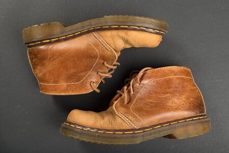 LONDON, ENGLAND - FEBRUARY 4, 2016: Old-fashioned and worn boots on gray background. Classic Dr....