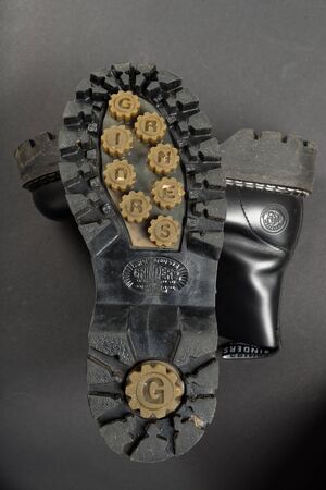 LONDON, ENGLAND - FEBRUARY 4, 2016: Old-fashioned and worn boots on gray background. Classic Dr. Martens models and classic Grinders models.のeditorial素材