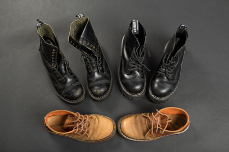 LONDON, ENGLAND - FEBRUARY 4, 2016: Old-fashioned and worn boots on gray background. Classic Dr. Martens models and classic Grinders models.のeditorial素材